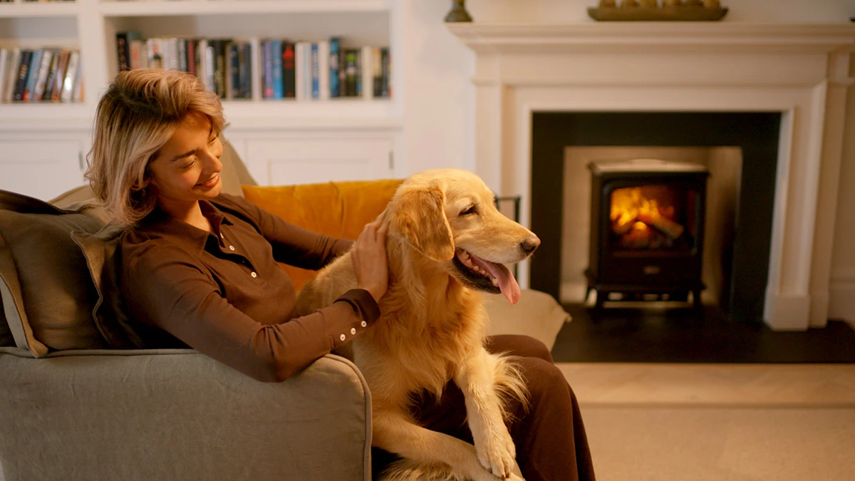 Family relaxing beside a glowing Dimplex Optimyst electric fire