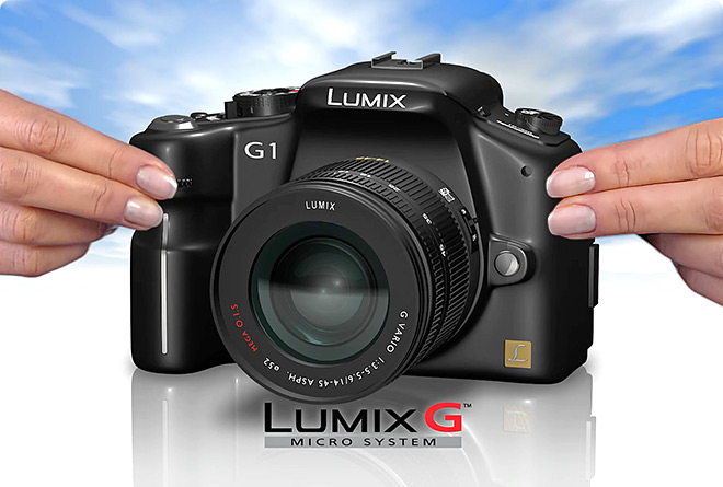 female hands holding a Panasonic Camera squeezing it to show that the camera is smaller than the average SLR